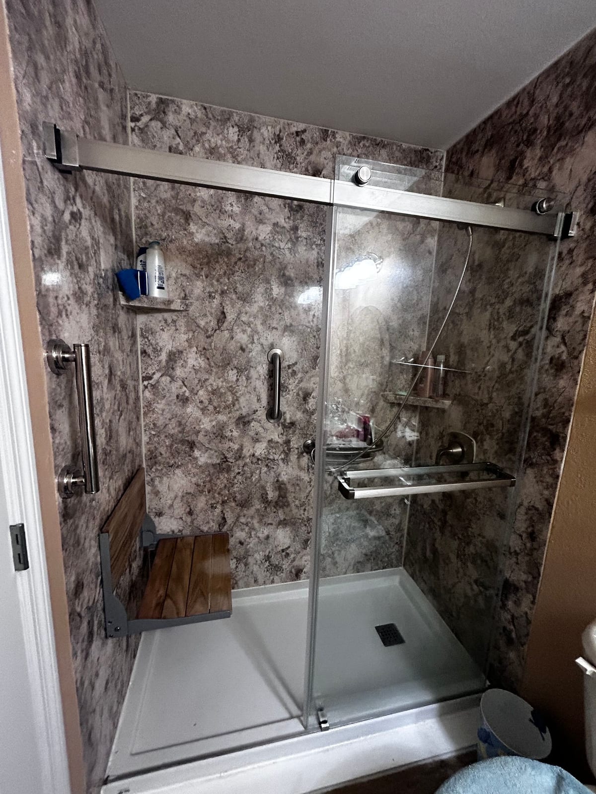Walk-in shower with grab bar and low threshold
