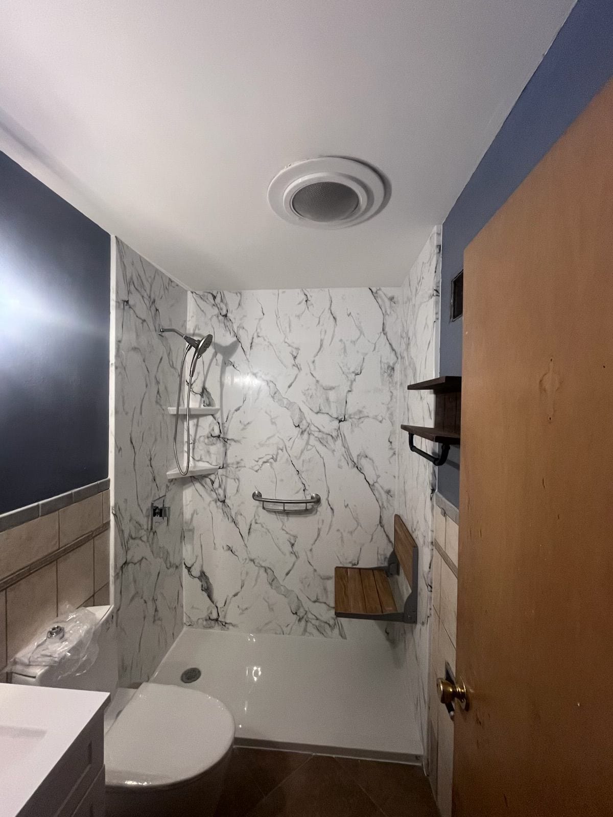 Marble-look walk-in shower with grab bar